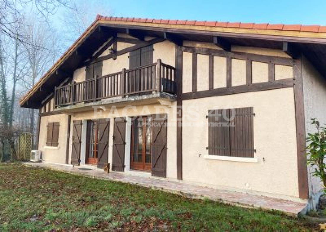 Maison traditionnelle avec balcons et volets en bois.