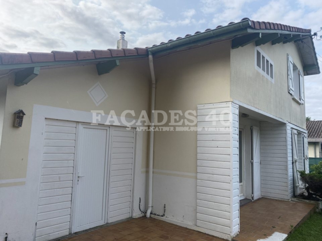 Façades 40 : Maison beige avec portes blanches et colonnes.