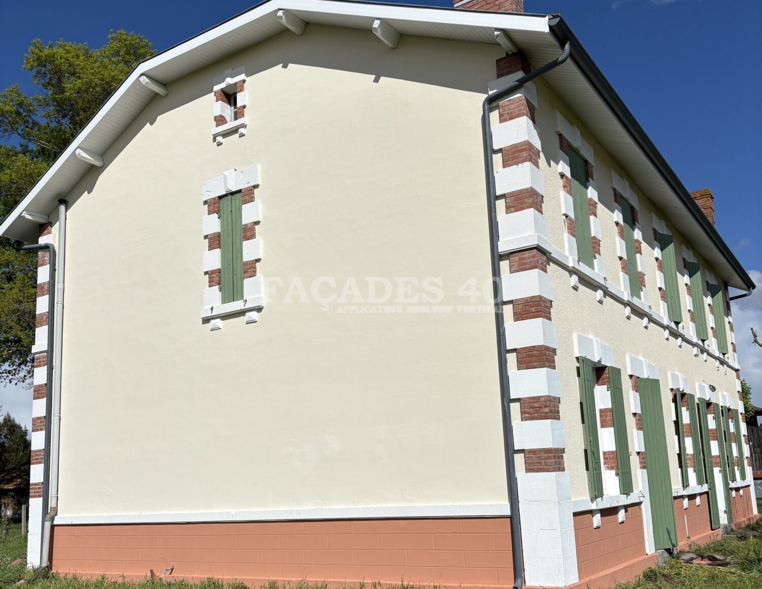 Façades 40 bâtiment blanc et vert avec volets