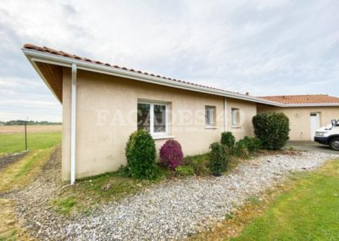 Maison unifamiliale avec jardin et voiture.